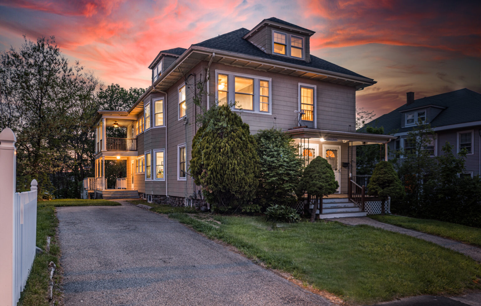 Dramatic twilight photography image of a double decker home displaying the front exterior and yard.