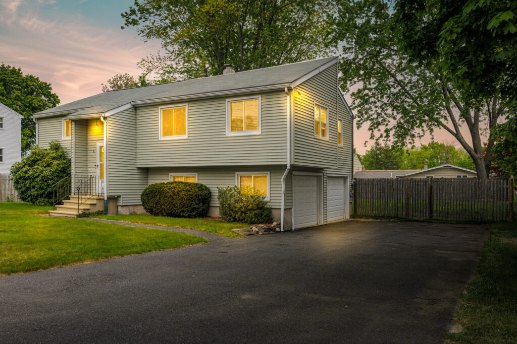 Dramatic twilight exterior image of the front of a split level home. This is an after image edited for virtual twilight.